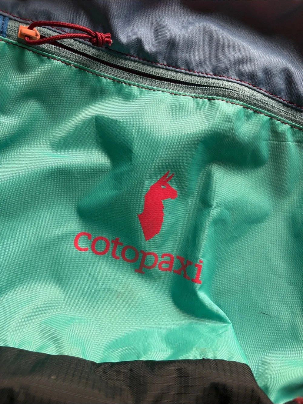 cotopaxi teal multicolor crossbody messenger bag with navy strap